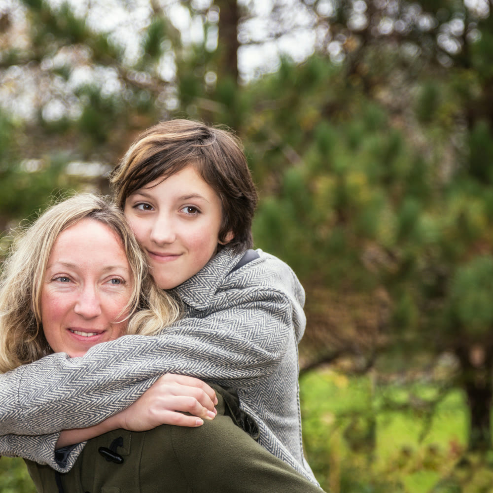 A parent and child embraced outdoors as a symbol of transition and becoming